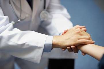 Doctor holding young boy's hand
