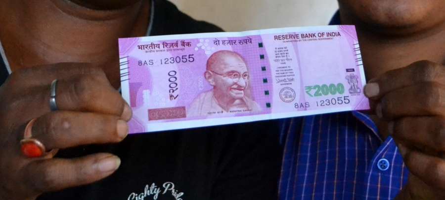 Guwahati: A man shows the new Rs 2000 currency note in Guwahati on Nov. 10, 2016. (Photo: IANS)