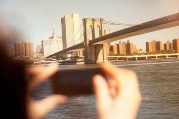 Hands taking picture of urban bridge and cityscape by .