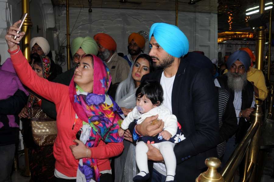Amritsar: Indian cricketer Harbhajan Singh with his wife Geeta Basra and daughter Hinaya Heer Plaha pay obeisance at the Golden Temple in Amritsar on Dec 22, 2016. (Photo: IANS) by .