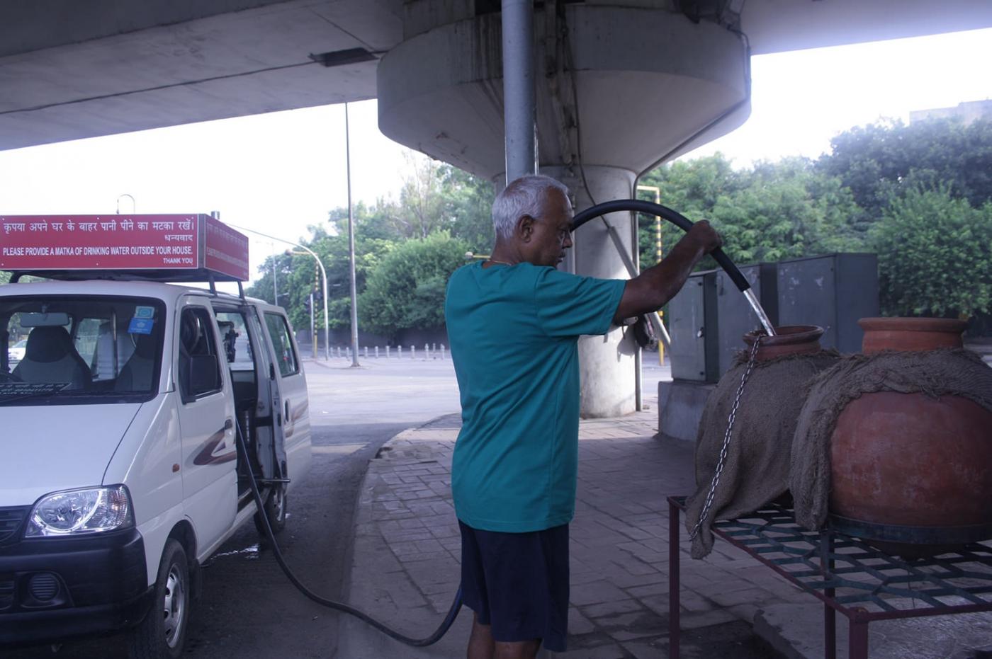69-year-old Alagarathanam Natarajan refilling the 'matkas' installed by him in Delhi. by .
