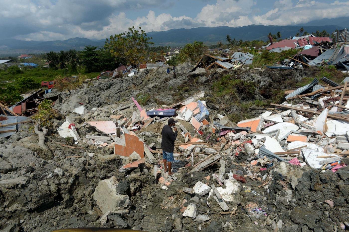 PALU, Oct. 3, 2018 (Xinhua) -- A local resident stands on the ruins at Petobo, in Palu, Central Sulawesi, Indonesia. Oct. 3, 2018. The death toll from Indonesia's multiple earthquakes and an ensuing tsunami jumped to 1,407 on Wednesday, the country's disaster management agency said. (Xinhua/Agung Kuncahya B./IANS) by .