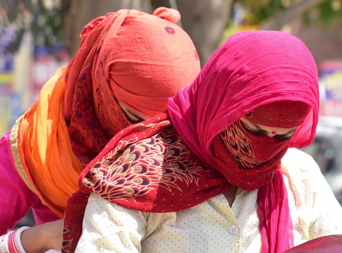 Women cover their faces to avoid scorching sun on a hot day. (File Photo: IANS) by .