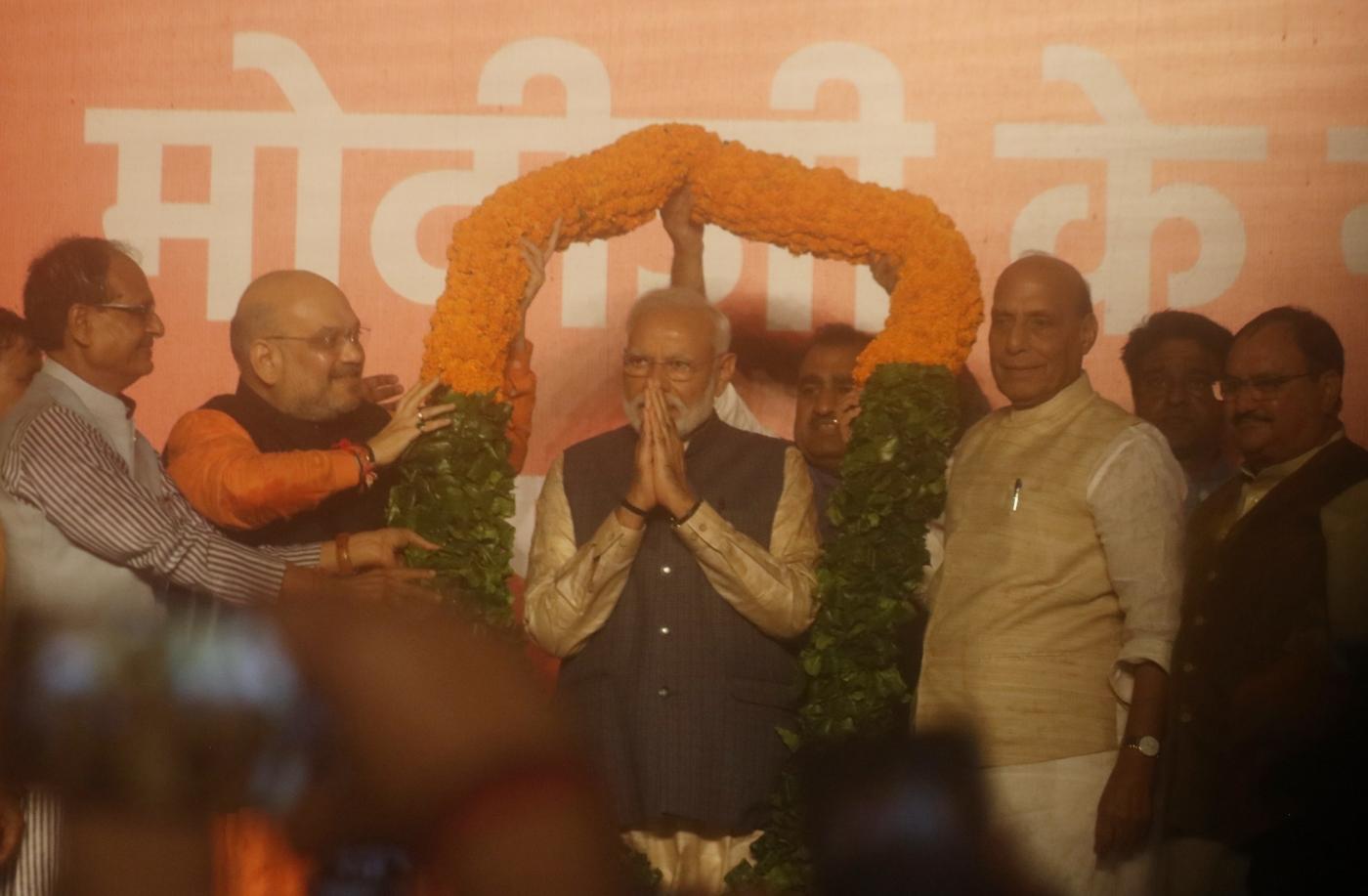 New Delhi: Prime Minister Narendra Modi being welcomed by BJP chief Amit Shah, party leader Shivraj Singh Chouhan and Union Ministers Rajnath Singh and J.P. Nadda, on his arrival to address party workers at the party's headquarters in New Delhi, on May 23, 2019. In a stunning electoral showing, the BJP led by Prime Minister Narendra Modi was on Thursday set to retain power for another five years after making a sweep of the Lok Sabha battle and mauling the opposition. (Photo: Bidesh Manna/IANS) by .