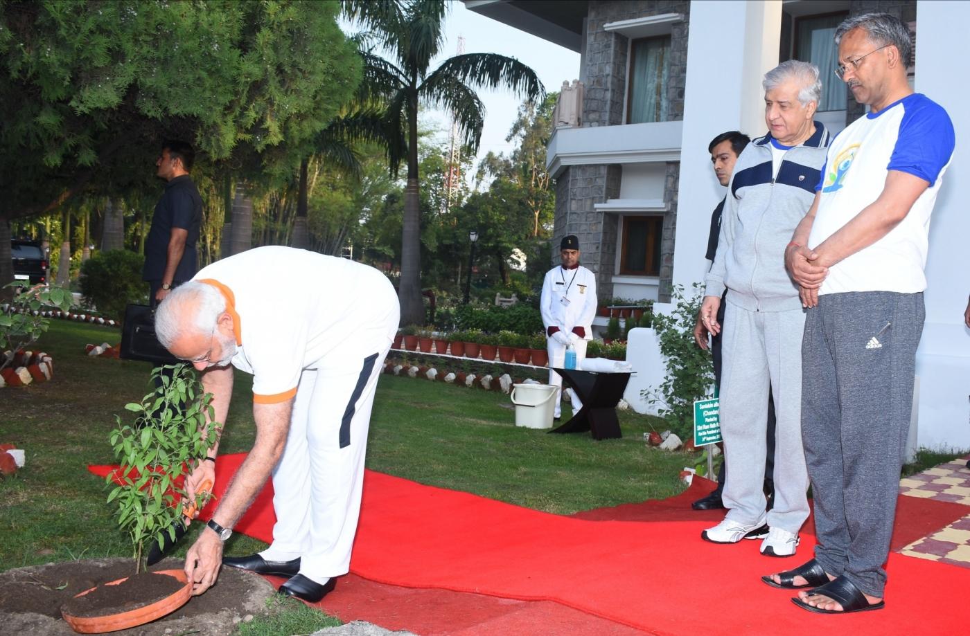 Dehradun: Prime Minister Narendra Modi plants a sapling at Raj Bhawan on the Fourth International Yoga Day in Dehradun on June 21, 2018. (Photo: IANS) by .