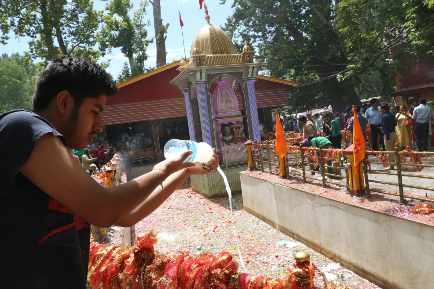 Srinagar: A devotee performs rituals during Kheer Bhawani Mela at Mata Kheer Bhawani Shrine in Jammu and Kashmir's Ganderbal district on June 20, 2018. Kashmiri Pandits started arriving here on Wednesday to pray for peace and prosperity at the shrine that is is dedicated to Hindu deity Mata Ragnya, who according to Hindu beliefs came to Kashmir from Sri Lanka during the rule of Ravana and is considered to be the holiest Kashmiri Pandit shrine in Kashmir Valley. (Photo: IANS) by .