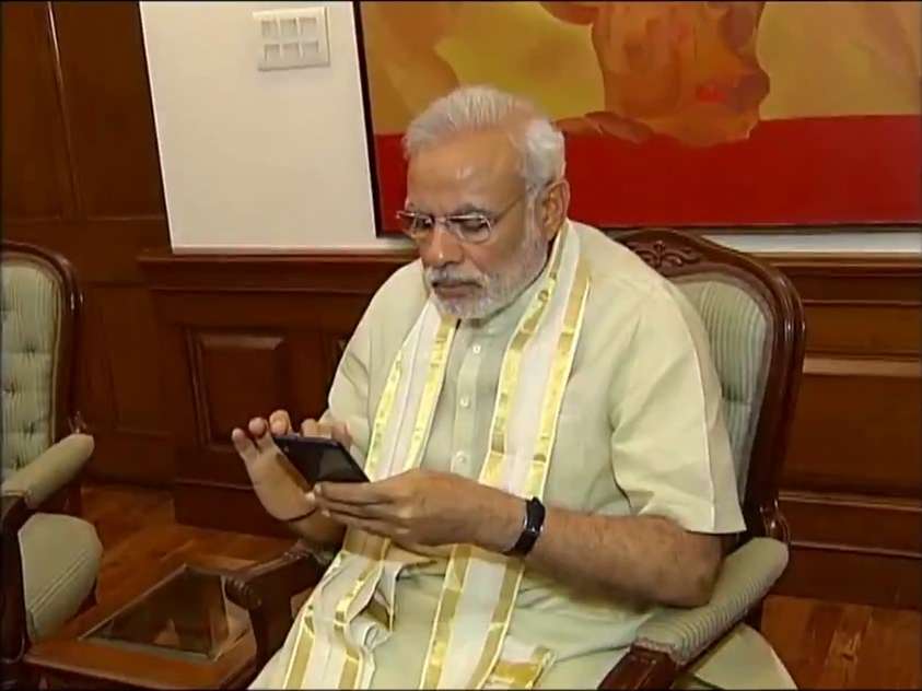 Prime Minister Narendra Modi busy working on his mobile phone. (Photo: IANS) by .