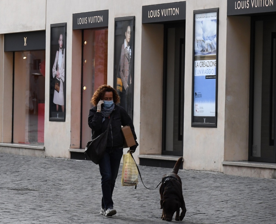 BERLIN, March 15, 2020 (Xinhua) -- A woman wearing a face mask walks a dog on the shopping street Via dei Condotti in Rome, Italy, on March 12, 2020. TO GO WITH XINHUA HEADLINES OF MARCH 15, 2020. (Photo by Elisa Lingria/Xinhua/IANS) by .