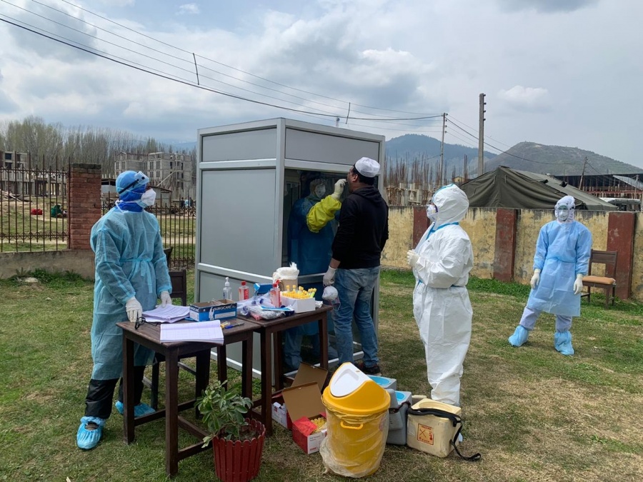Baramulla: A medical worker collects sample from a person for COVID-19 tests at a 'Booth type sampling Centre' set up in Jammu and Kashmir's Baramulla amid cornavirus pandemic, on Apr 7, 2020. (Photo: ANS) by . 